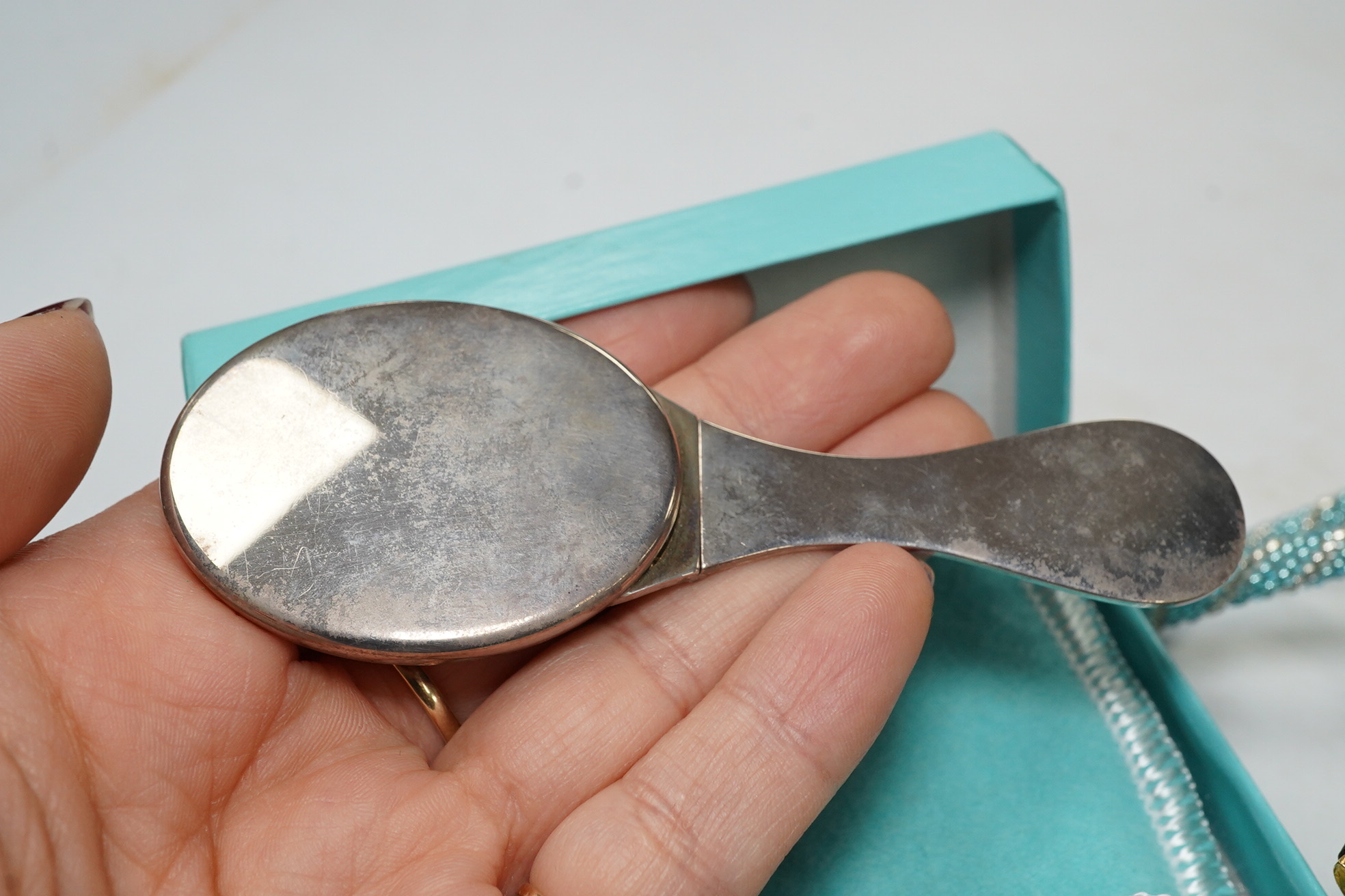 A small quantity of assorted costume jewellery including a Scottish hardstone brooch and a Tiffany & Co. folding silver mirror. Condition - fair to good